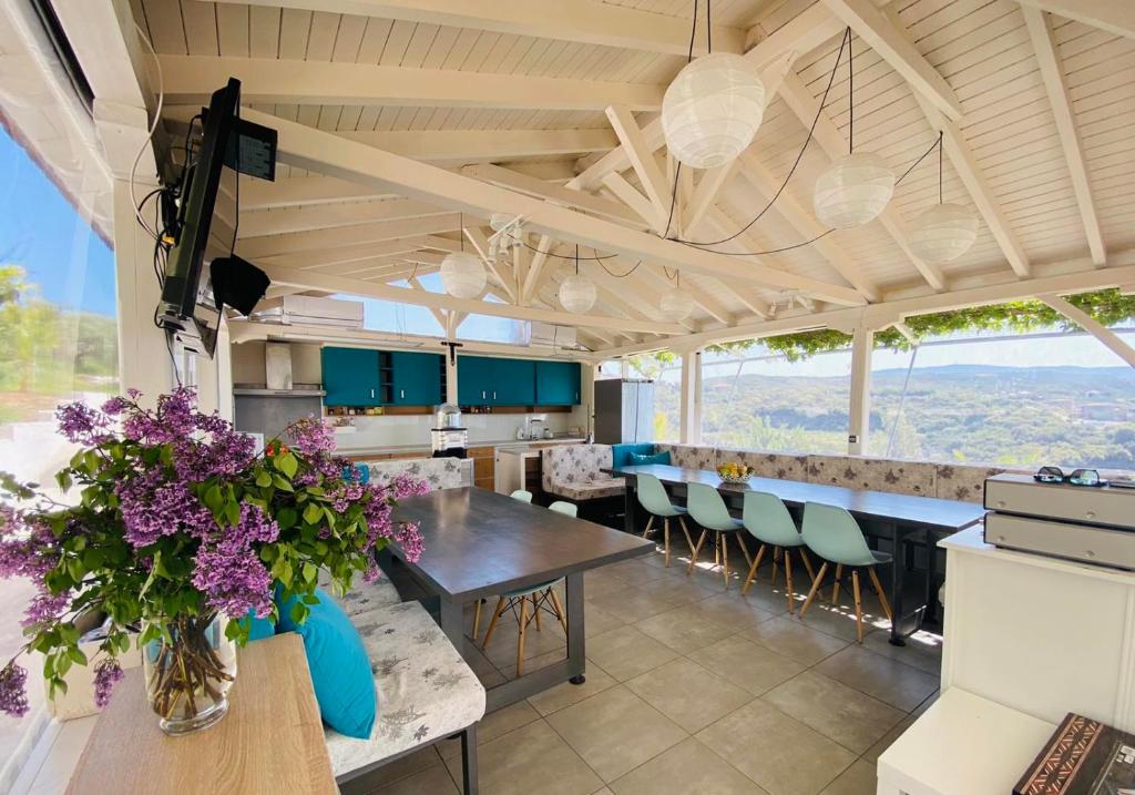 a kitchen with a long table and chairs and purple flowers at Dream Hill Athos in Ouranoupoli