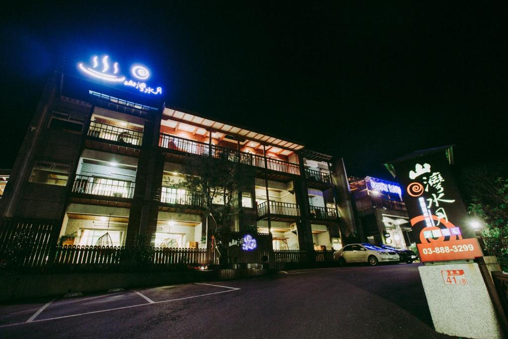 玉里鎮的住宿－Water Moon山灣水月溫泉會館，一座建筑物,晚上在建筑物的一侧有标志