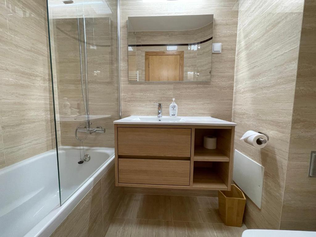 a bathroom with a sink and a shower and a tub at Figueira Centro Apartment by Rent4All in Figueira da Foz