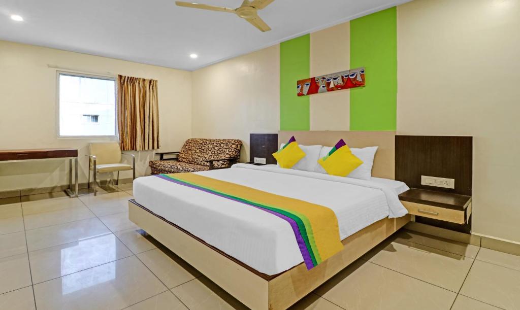 - une chambre avec un grand lit et un mur coloré dans l'établissement Itsy By Treebo - G Square, à Vijayawada