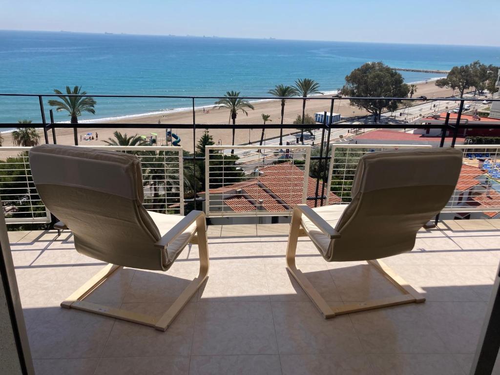 two white chairs sitting on a balcony looking at the ocean at Heliopolis vista mar Orangecosta in Benicàssim