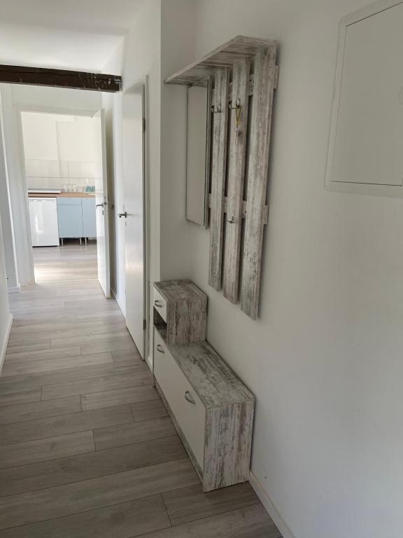 un pasillo con una pared blanca con un banco y un espejo en Zentral gelegenes Apartment am Bunter Garten en Mönchengladbach