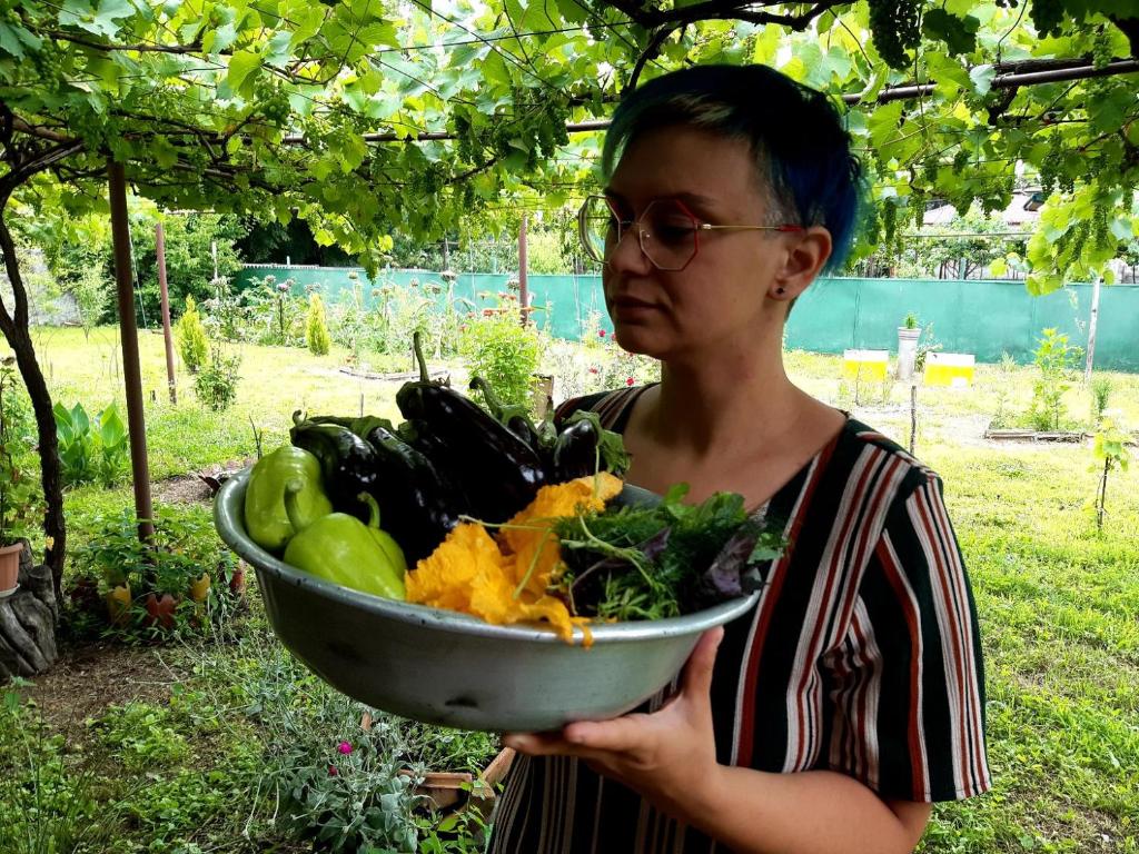 a woman is holding a bowl of vegetables at Nodara's garden in Lagodekhi