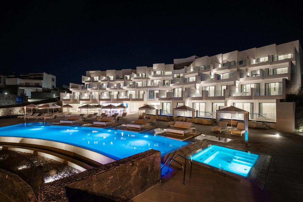 a hotel with a swimming pool at night at Royal Marina Suites Boutique Hotel - Adults Only in Puerto Calero