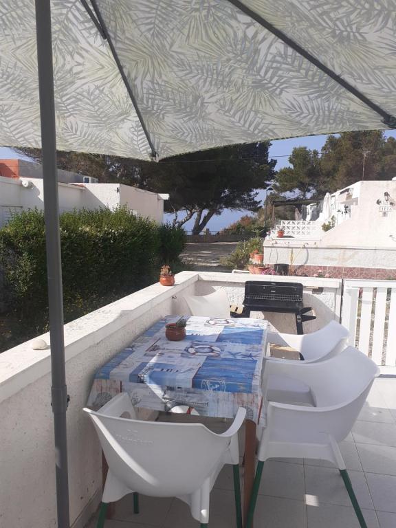 einen Tisch und Stühle unter einem Zelt auf einem Balkon in der Unterkunft Mi morena cala llobeta 35 in L'Ametlla de Mar