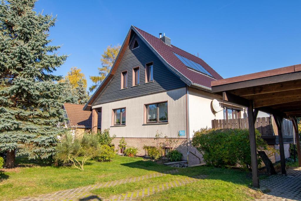 a house with a black roof and a yard at Ferienwohnung im Souterrain in Freest