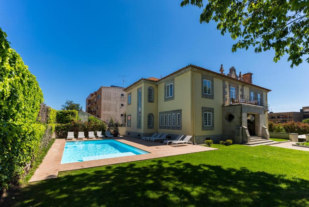 a house with a swimming pool in the yard at 3 Marias Residence in Viana do Castelo