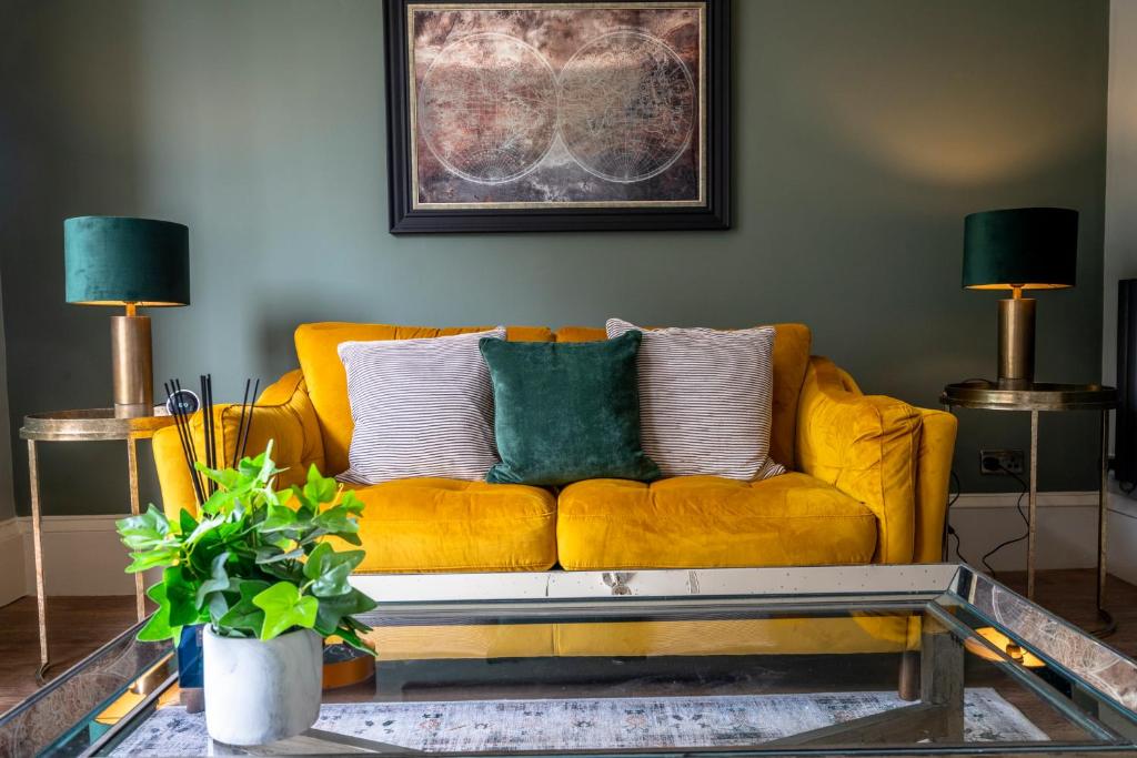 un sofá amarillo en una sala de estar con 2 lámparas en The Chambers at The Dukes Townhouse, en York
