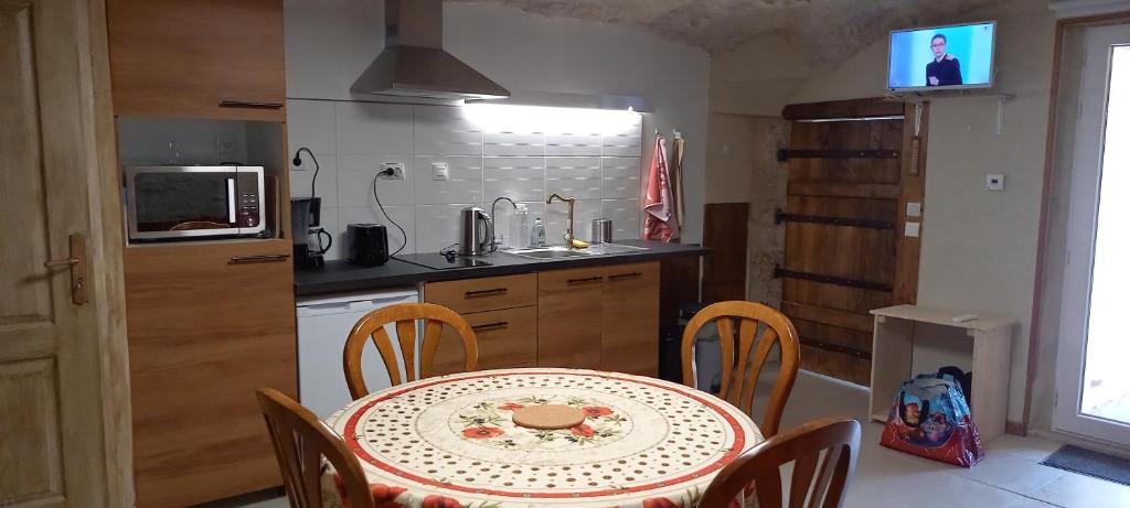 une cuisine avec une table et des chaises dans l'établissement gite-civray-de-touraine TROGLO de Denise, à Civray-de-Touraine