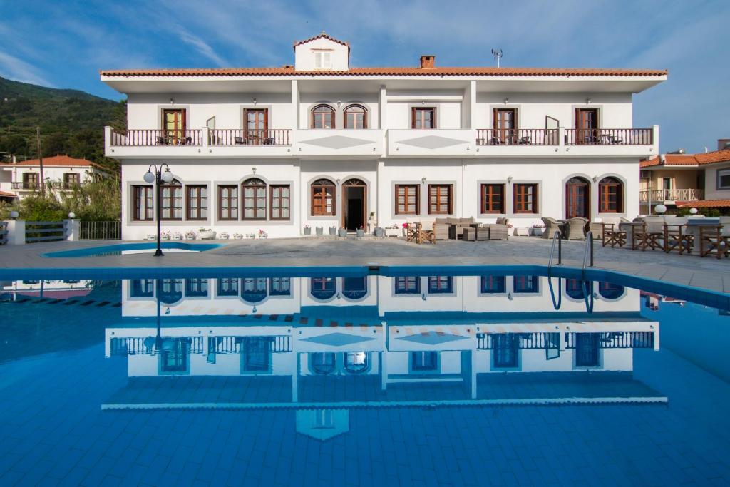 a large white house with a swimming pool in front of it at Iro's Residence in Ágios Konstantínos