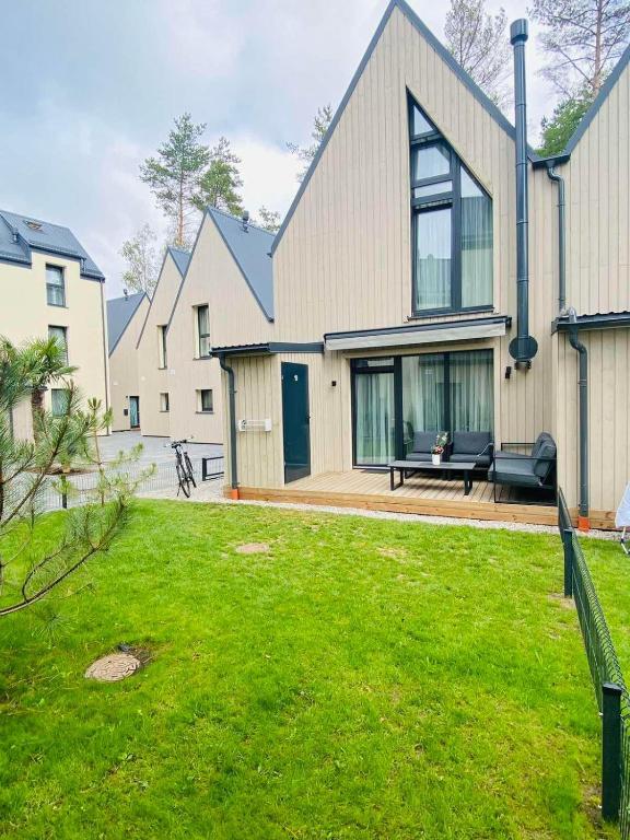 a house with a green lawn in front of it at Sun&Sea in Palanga