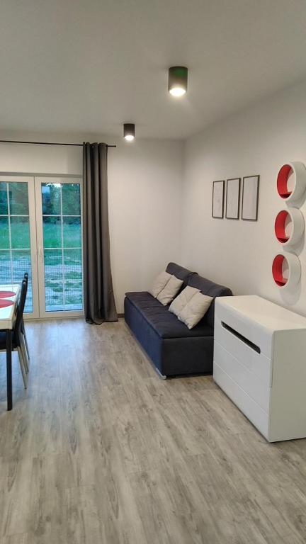 a living room with a couch and a table at Apartamenty wakacyjne in Ślesin