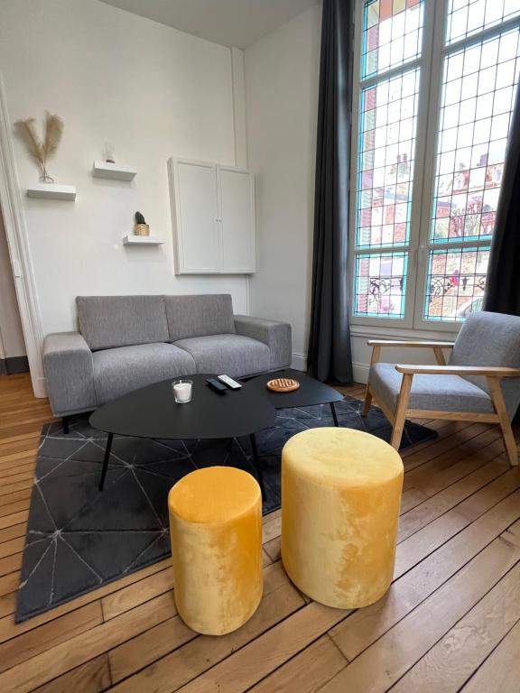 ein Wohnzimmer mit einem Sofa und einem Tisch in der Unterkunft F2 Magnifique au Cœur du Centre ville in Caen