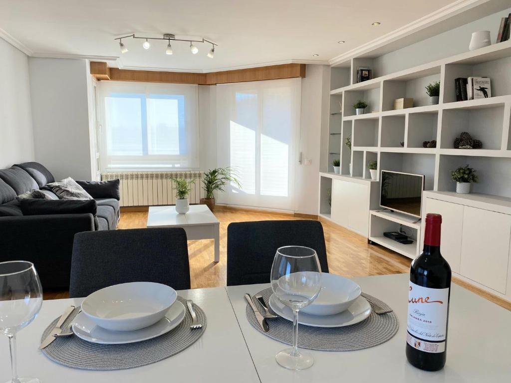 - une bouteille de vin assise sur une table dans le salon dans l'établissement Piso en Logroño espacioso, con vistas y garaje, à Logroño