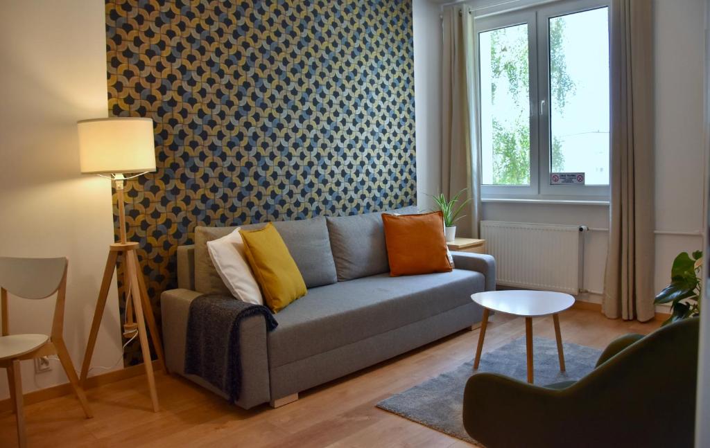 uma sala de estar com um sofá azul e uma janela em Nest Centrum Konin em Konin