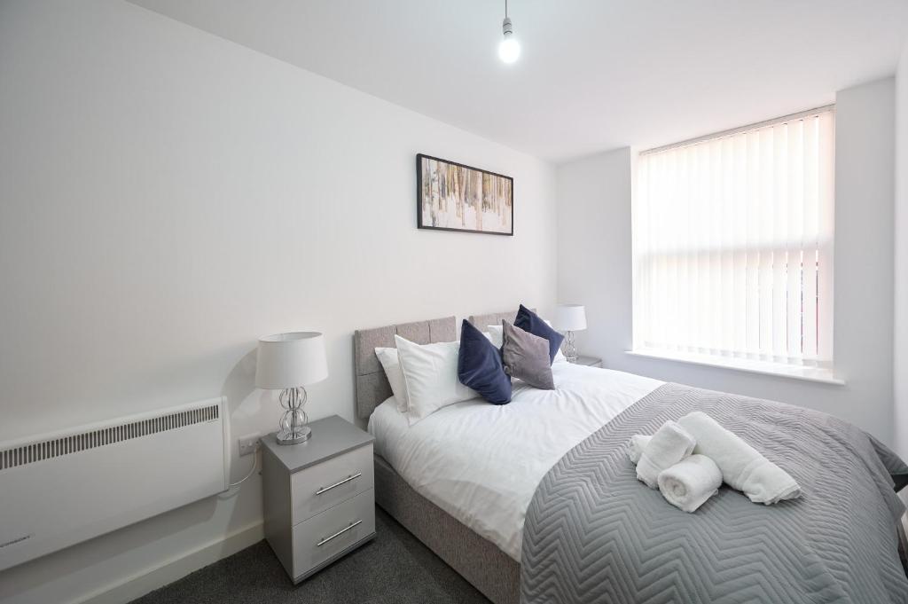 Habitación blanca con cama y ventana en Winckley House Serviced Apartments in Preston, en Preston