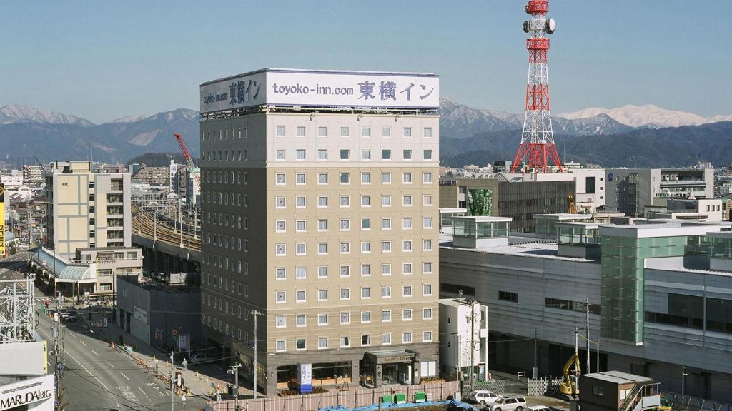 Un edificio alto con un cartel encima. en Toyoko Inn Fukui Ekimae, en Fukui