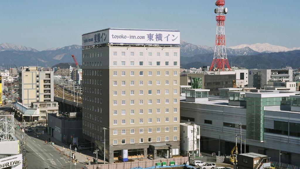 Un palazzo alto con un cartello sopra. di Toyoko Inn Fukui Ekimae a Fukui