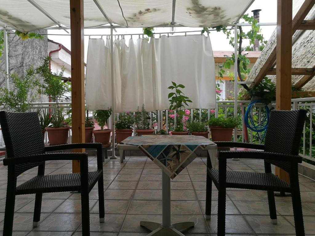 eine Terrasse mit 2 Stühlen und einem Tisch und einigen Pflanzen in der Unterkunft small booking room in Sarti