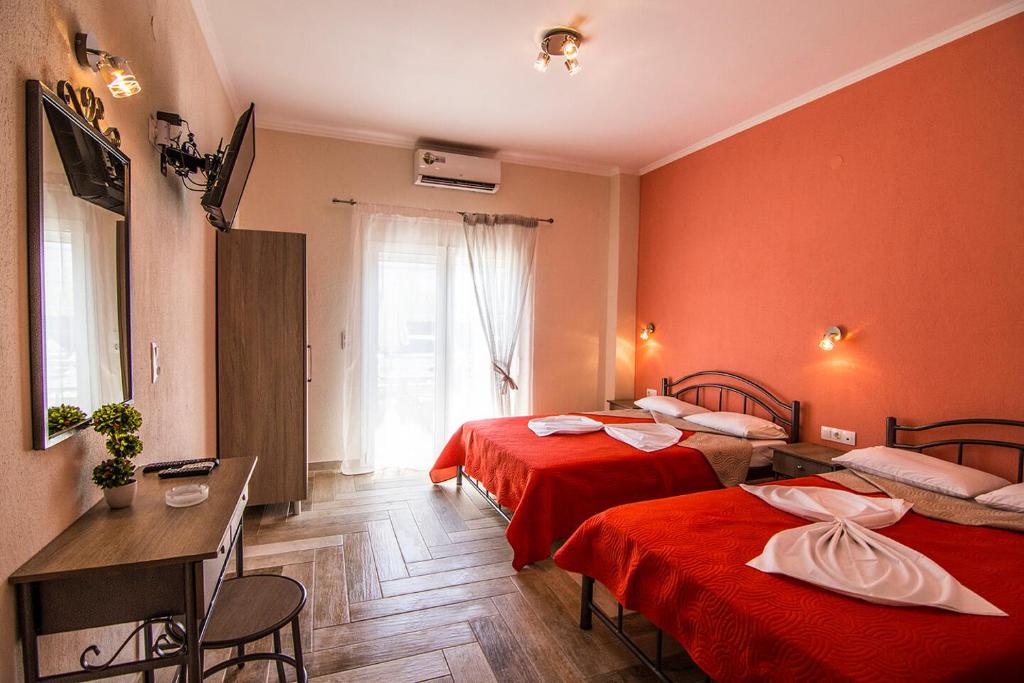 a hotel room with two beds and a table and chairs at Christodoulos Eleftheria House in Nea Vrasna