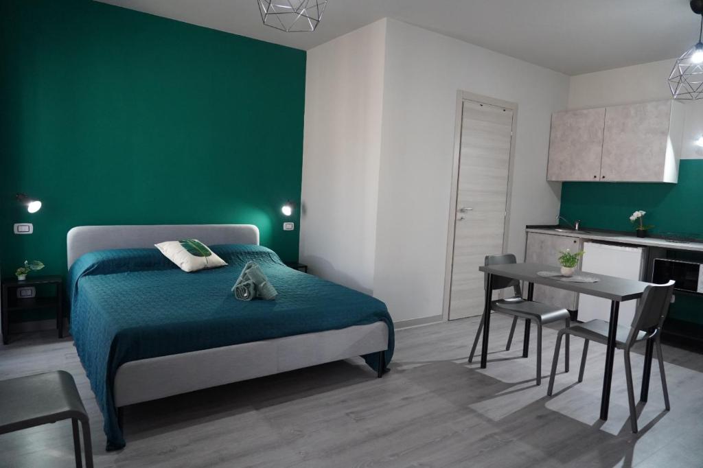 a green bedroom with a bed and a table at 4ROOMS b&b - HOLIDAY HOME in Lamezia Terme