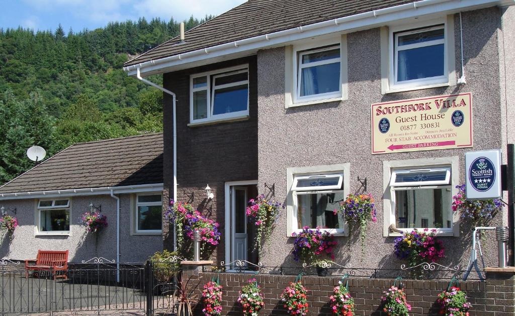 a house with flowers in front of it at Southfork Villa Guesthouse in Callander