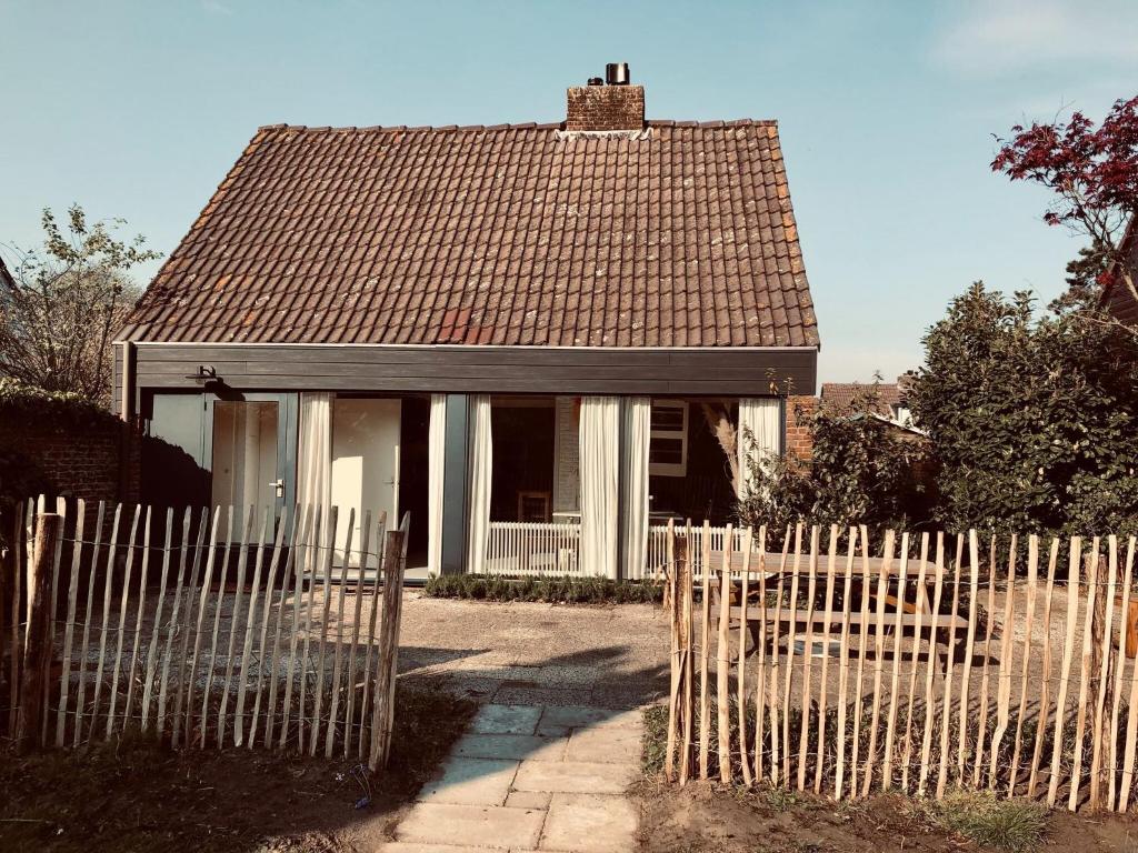 a small house behind a white picket fence at Clair de Lune in Noordwijkerhout