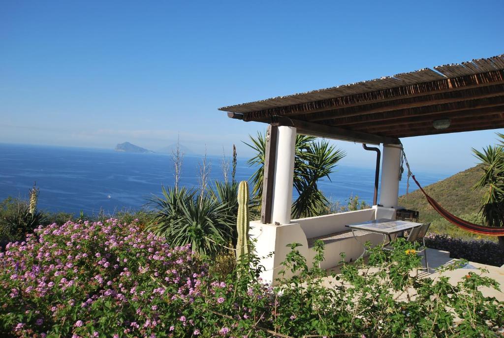 a view of the ocean from a house with flowers at Atollo in Lipari