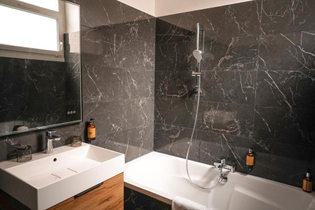 a bathroom with a sink and a bath tub at Hôtel Saint-Julien in Angers