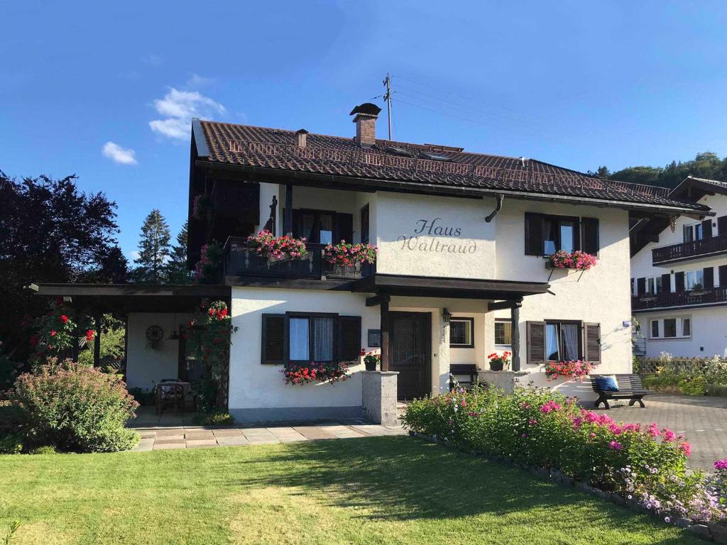 um edifício branco com caixas de flores nas janelas em Haus Waltraud em Bad Wiessee