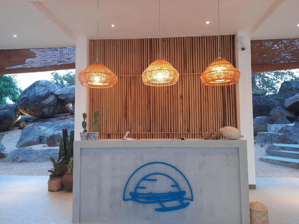 a lobby with two chandeliers and a counter with a sign at Oruwa Boutique Villas in Arugam Bay