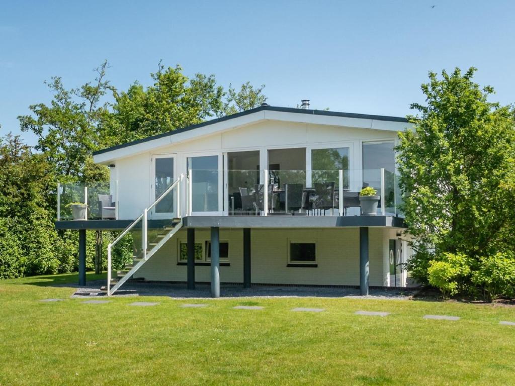 uma casa com grandes janelas e um relvado em Majestic holiday home in Kamperland with garden em Kamperland