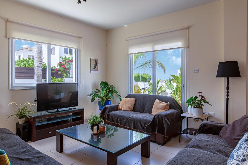 ein Wohnzimmer mit einem Sofa und einem TV in der Unterkunft Villa Nova in Protaras