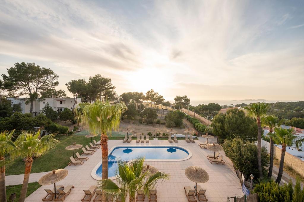 una vista aérea de un complejo con piscina y palmeras en Apartamentos Blanco Sol, en Cala Vadella