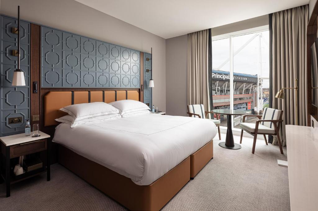 a hotel room with a large bed and a table at The Parkgate Hotel in Cardiff