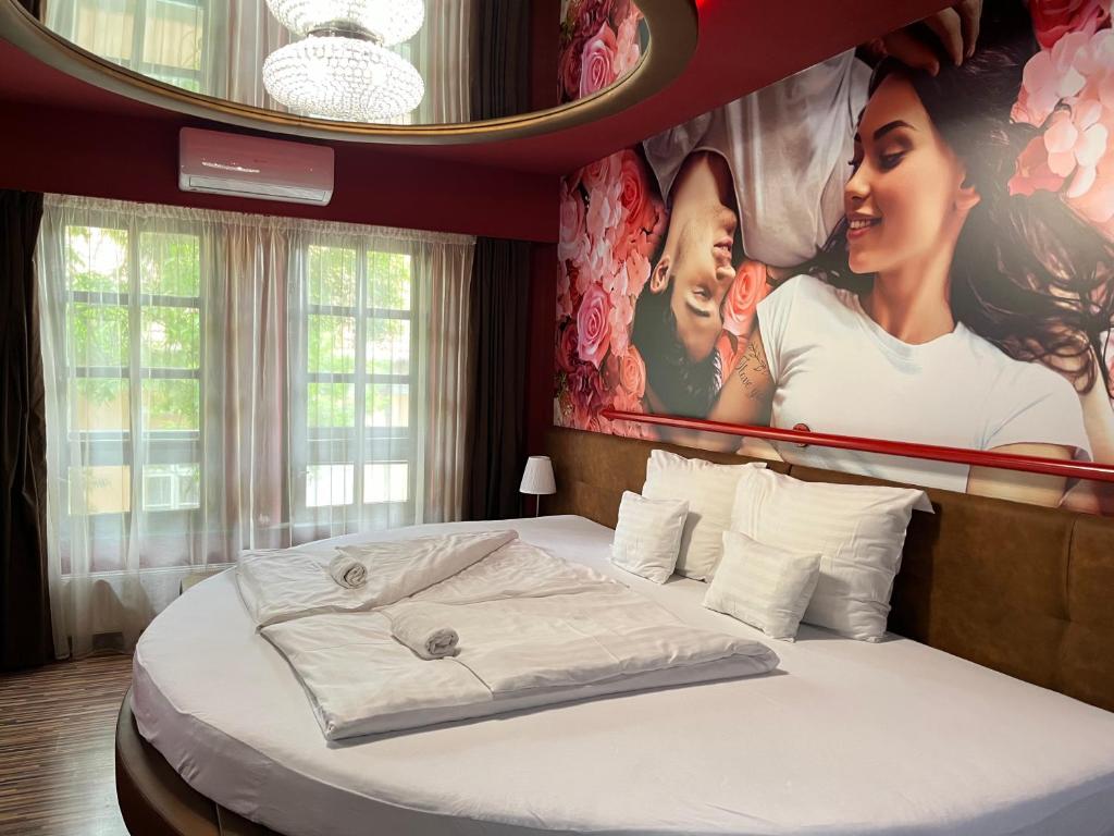 a bedroom with a bed with a poster on the wall at Hotel Corvin in Gyula