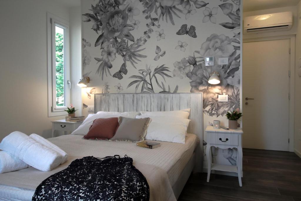 una camera da letto con un letto bianco e fiori sul muro di Bed & Basta a Reggio Emilia