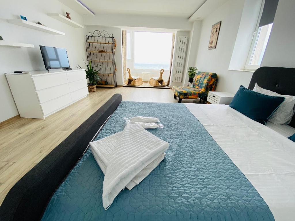 a bedroom with a large bed with a blue rug at Sea View Studio in Constanţa