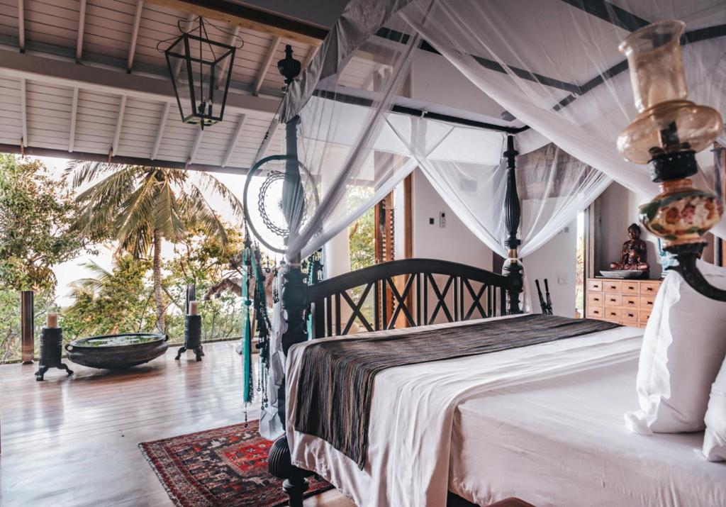 a bedroom with a bed with a canopy at Villa SPACE in Unawatuna