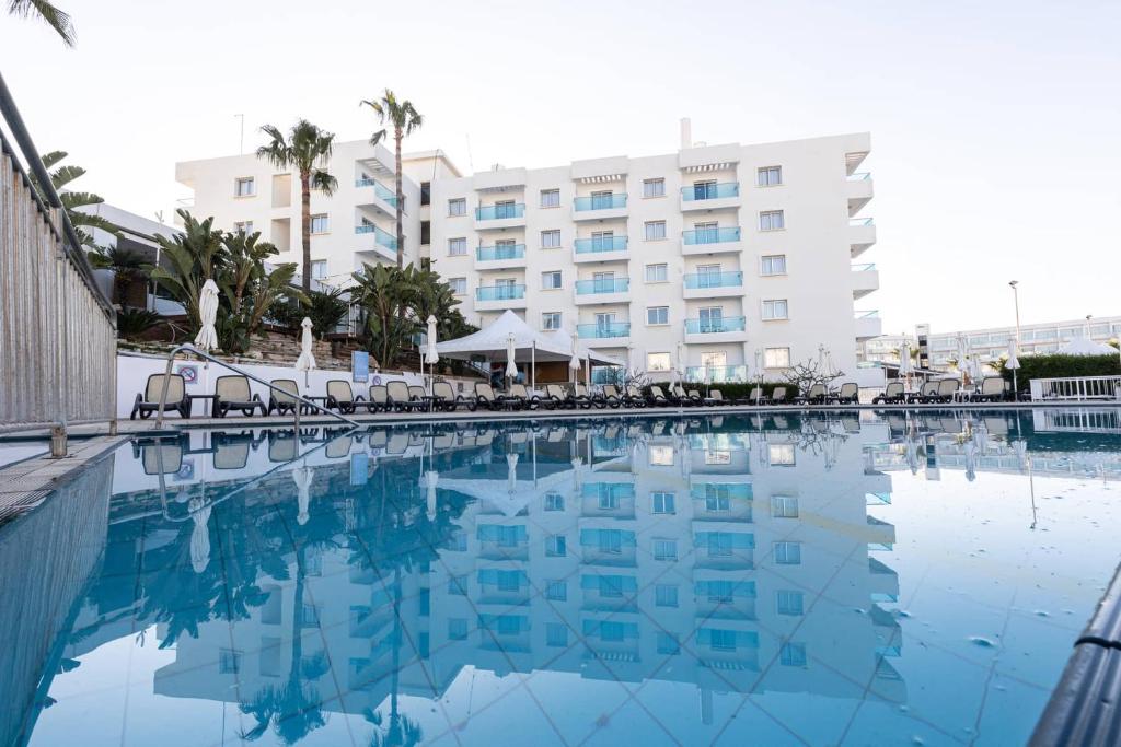 a swimming pool in front of a hotel at Vrissaki Hotel Apartments in Protaras