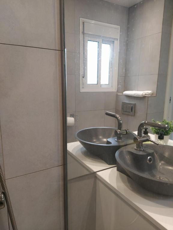łazienka z 2 umywalkami i lustrem w obiekcie Acogedor y moderno estudio en Capuchinos w Maladze