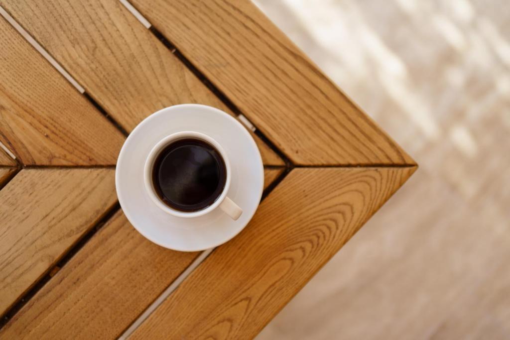a cup of coffee sitting on a wooden table at Costa Maya Bodrum in Bodrum City