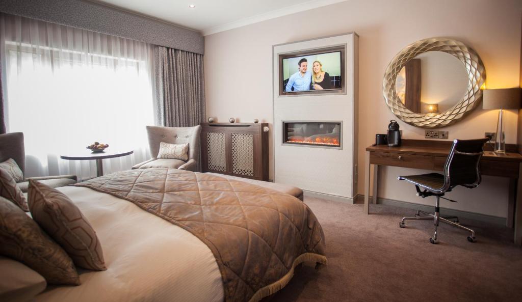 a bedroom with a bed and a desk and a mirror at The Lodge Hotel in Coleraine