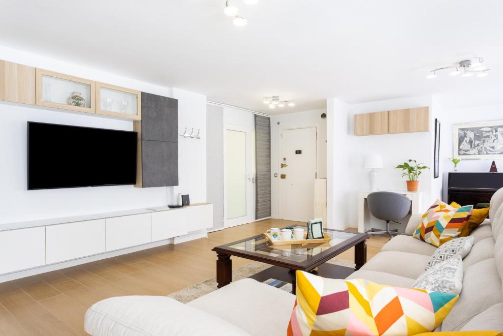 a living room with a couch and a tv at Home2Book Elegance City Center Apartment in Santa Cruz de Tenerife