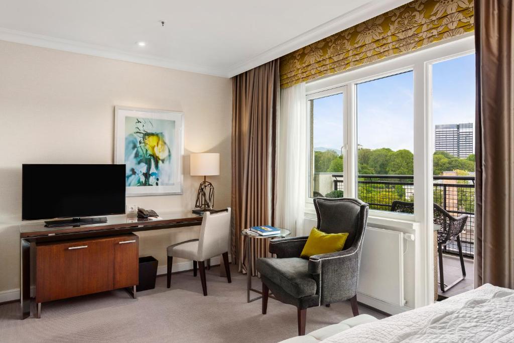 a hotel room with a desk with a computer and a window at Hotel Continental in Oslo