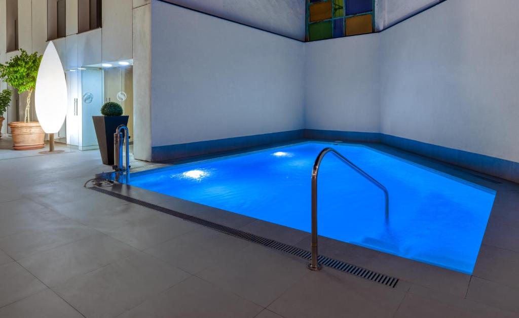 a swimming pool with a blue tub and blue floor at Hotel Virgen de los Reyes in Seville