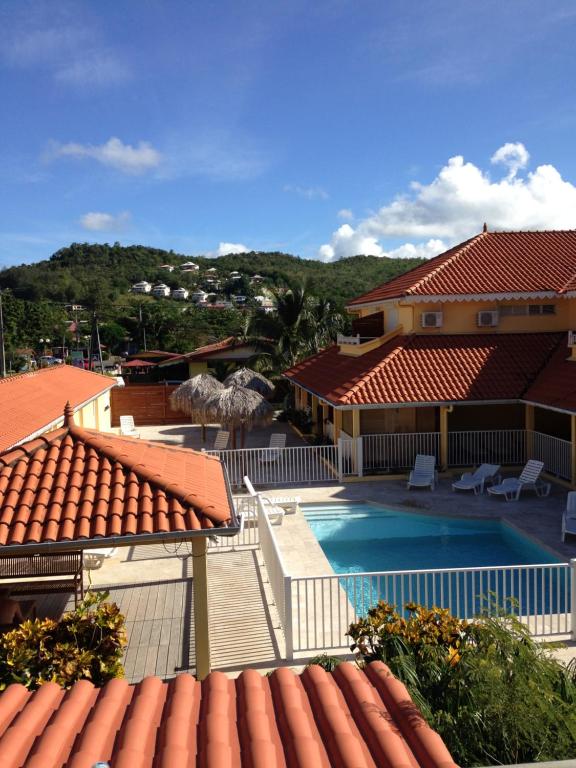 een uitzicht vanaf het dak van een huis met een zwembad bij Appartement en résidence 50m plage in Les Trois-Îlets