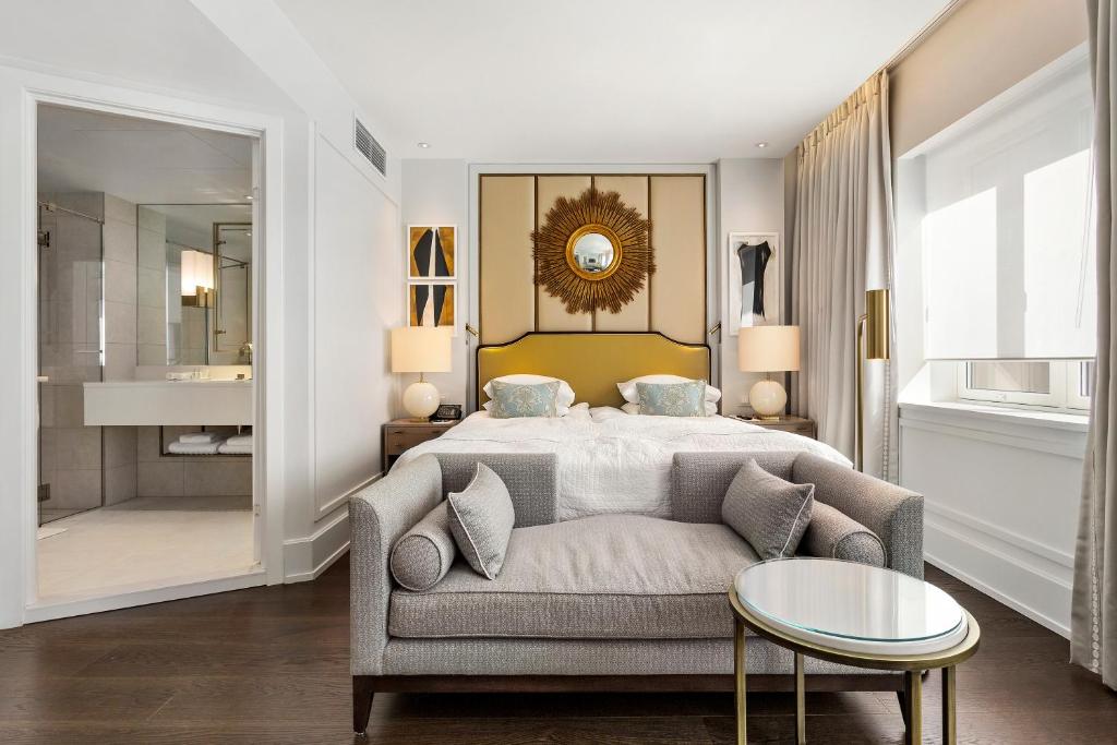 a bedroom with a bed and a couch and a table at Hotel Continental in Oslo