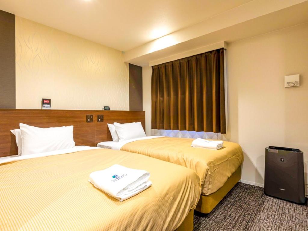 Postel nebo postele na pokoji v ubytování HOTEL LiVEMAX Okazaki