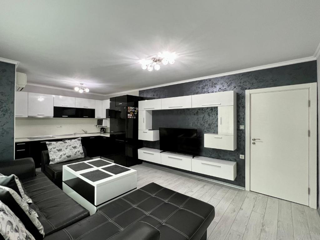 a living room with a couch and a tv at TEA Apartments in Pomorie